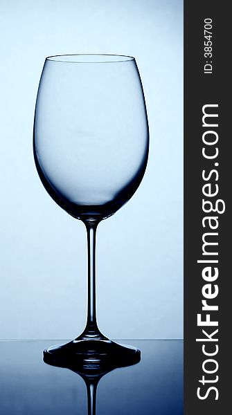 Wine glass with reflection over blue background