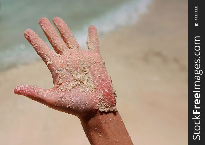 A white wet sand in sunburned hand