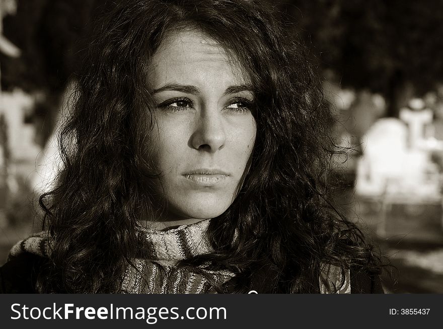 Sad woman sitting by grave in cemetery. Sad woman sitting by grave in cemetery