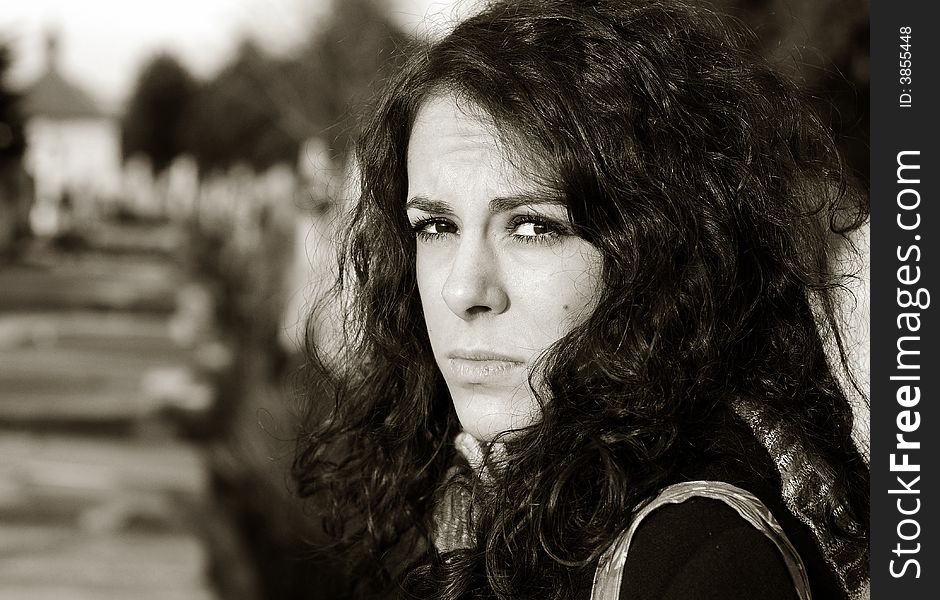 Sad woman sitting by grave in cemetery. Sad woman sitting by grave in cemetery