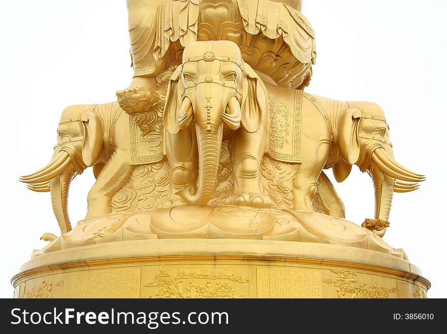 Four elephants stand at base frame of enormous golden Buddha statue a top of Emeishan mountain, China