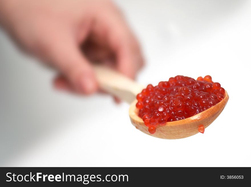 Red caviar in a wooden spoon. Red caviar in a wooden spoon