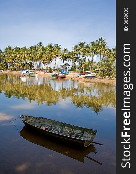 Peaceful and serene tropical village by the river with coconut trees. Peaceful and serene tropical village by the river with coconut trees