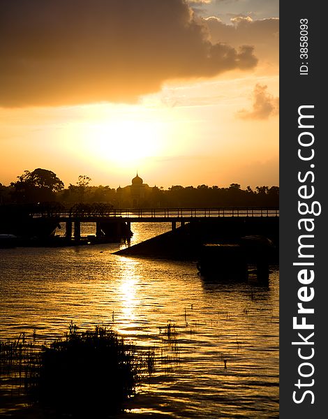 Beautiful orange sunset of an Islamic mosque by the river. Beautiful orange sunset of an Islamic mosque by the river