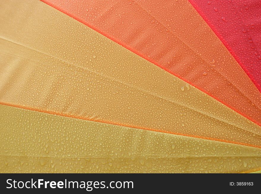 Close up from a wet colorful umbrella.