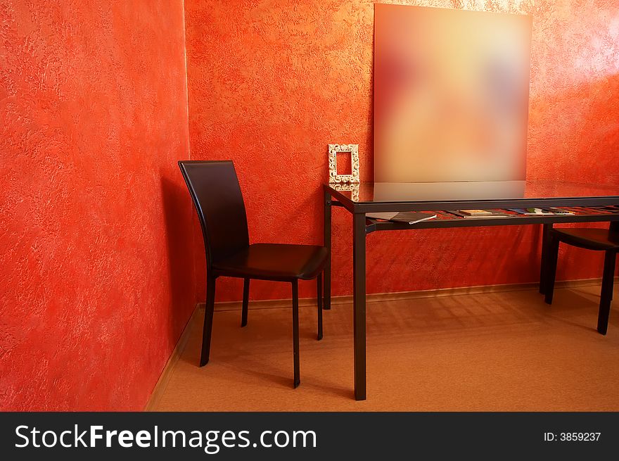 Chair and table on a background of a red wall