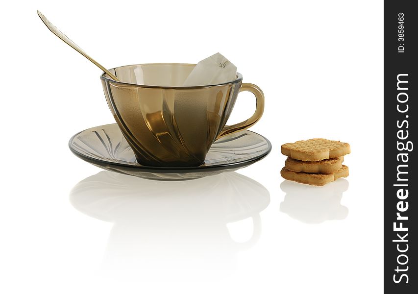 Empty glass teacup with cookie, sugar and tea bag. Empty glass teacup with cookie, sugar and tea bag.