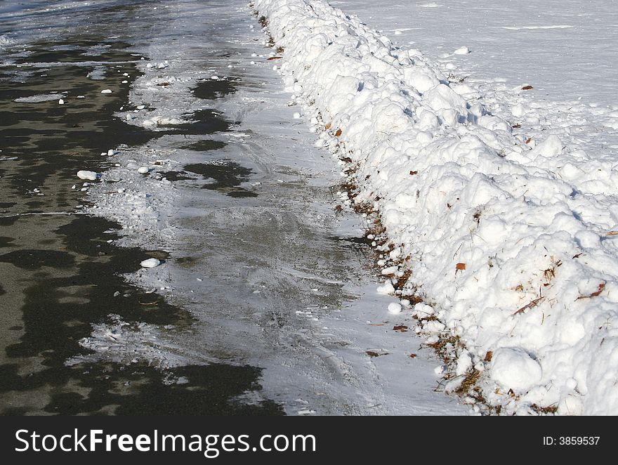 A freshly snow shoveled path in the sun after a storm