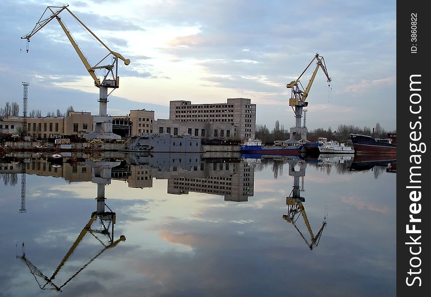 Shipyard view reflected in water