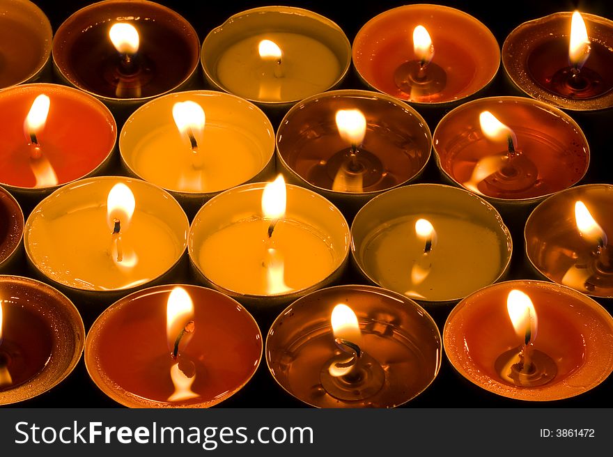 A group of burning candles on the black background