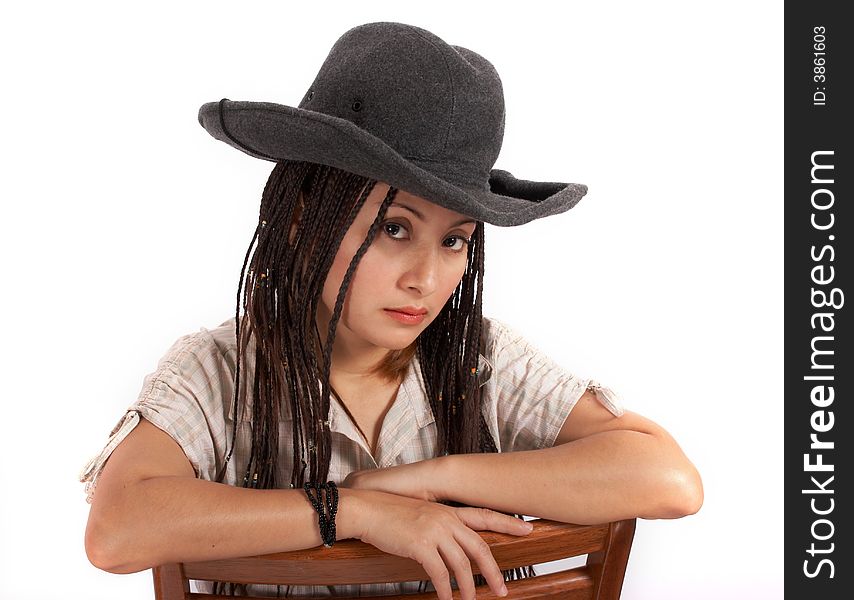 A sexy cowgirl sitting on a chair over a white background