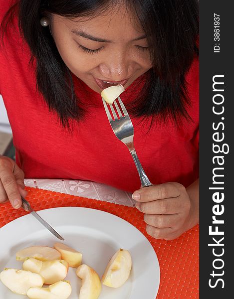 Woman eating an apple over the plate. Woman eating an apple over the plate