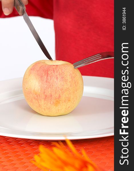 Human trying to slice an apple over a plate. Human trying to slice an apple over a plate