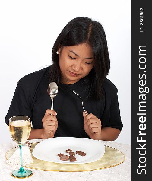 Woman holding spoon and fork with chocolates and wine. Woman holding spoon and fork with chocolates and wine