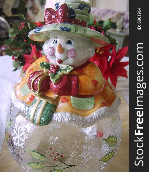 Snowman cookie jar with a poinsetta plant. Snowman cookie jar with a poinsetta plant