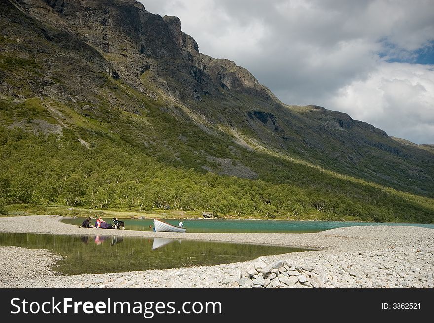 Picnic on the Gjende beach under the Bessegen ridge in Jotunheimen national park. Picnic on the Gjende beach under the Bessegen ridge in Jotunheimen national park.