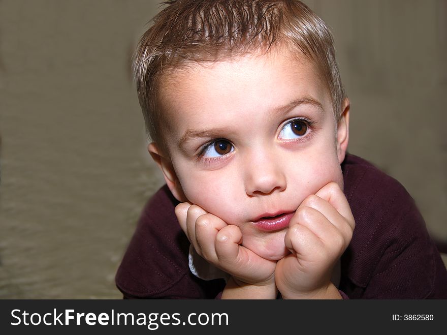 Boy posing chin on hands against muslin background sdof. Boy posing chin on hands against muslin background sdof