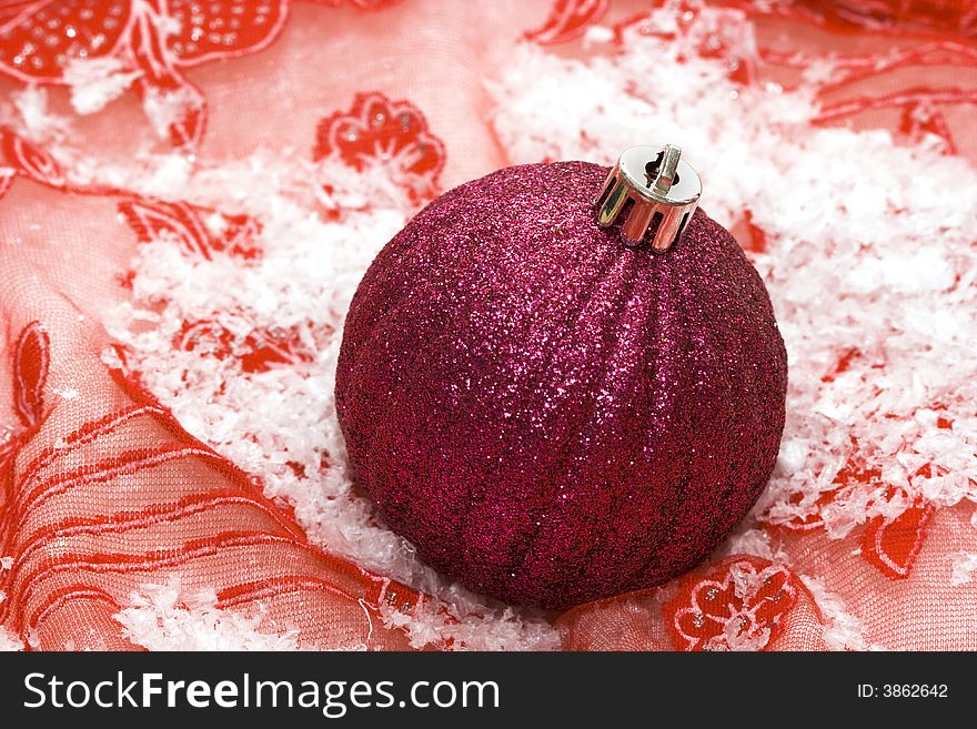 Pink Christmas ball on snow background