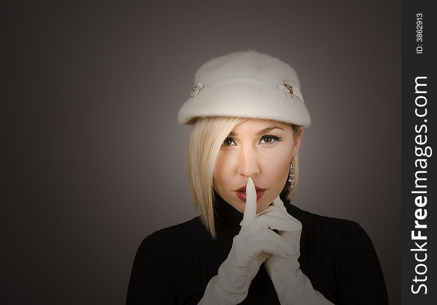 A blonde model in white hat and gloves with spotlight on face. A blonde model in white hat and gloves with spotlight on face