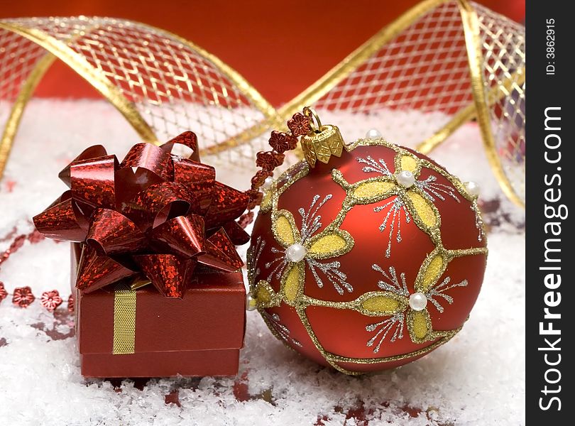 Red Christmas balls and gift on snow