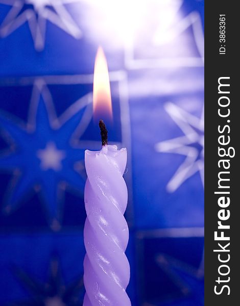 Violet candle on blue background