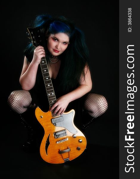 Beautiful young woman with blue and black hair with electric guitar. Beautiful young woman with blue and black hair with electric guitar.