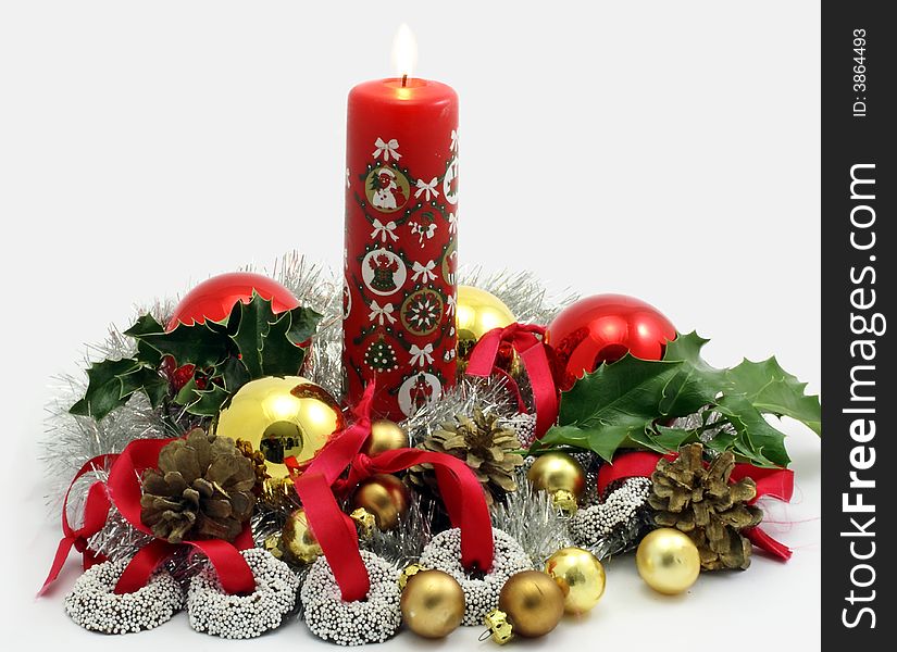 Christmas decoration with burning candle, ornaments and chocolate sweets on ribbons to hang in the tree