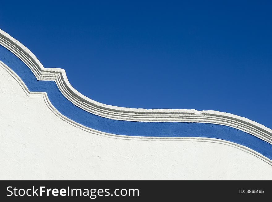 Top of a garnished curved wall adorned with a blue strip. Top of a garnished curved wall adorned with a blue strip