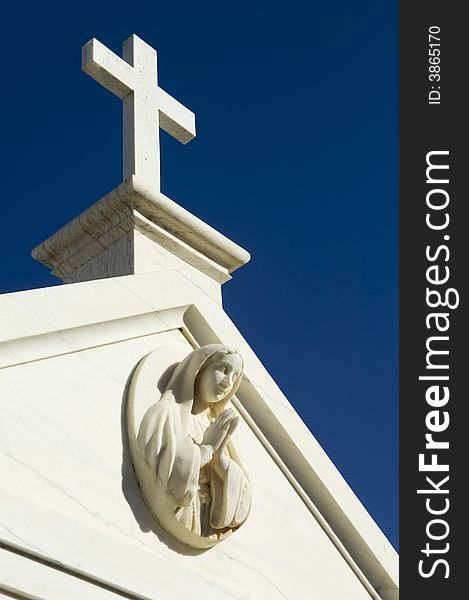 Cemetery mausoleum detail showing a saint praying