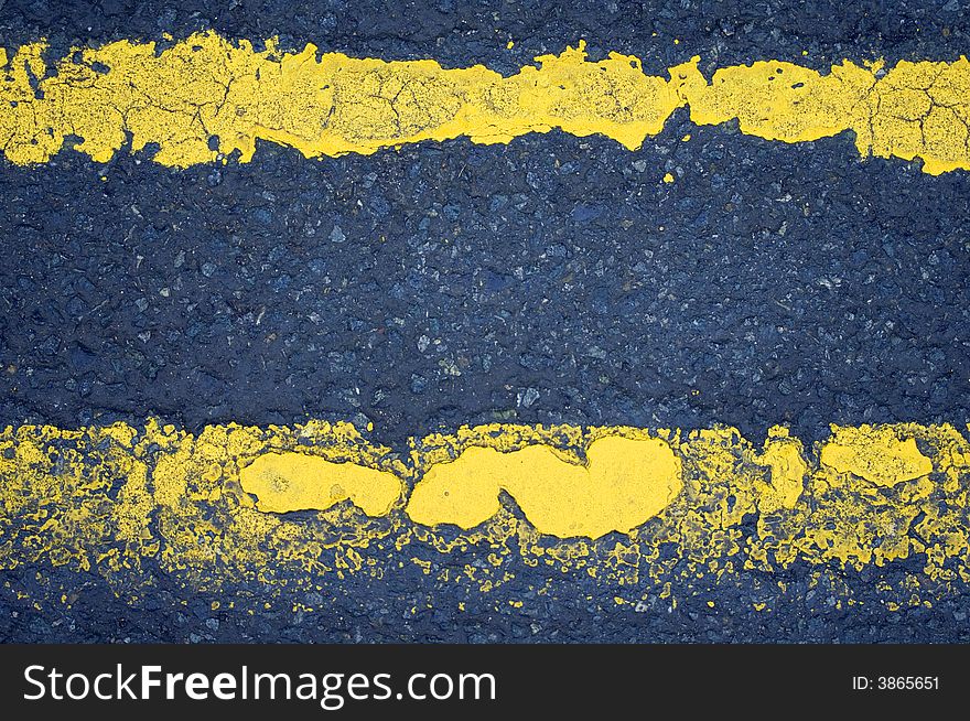 Worn road markings (double yellow lines) with an interesting texture.