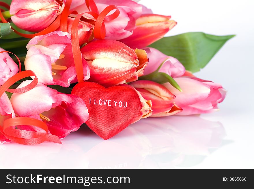 Bunch of tulips and red heart over white background