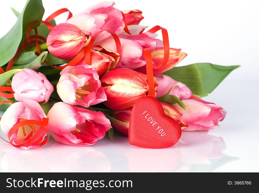Bunch of tulips and red heart over white background
