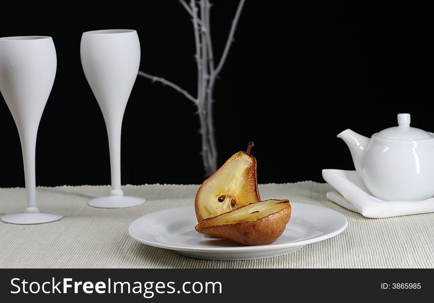 A gormet roasted pear with a modern table setting. A gormet roasted pear with a modern table setting
