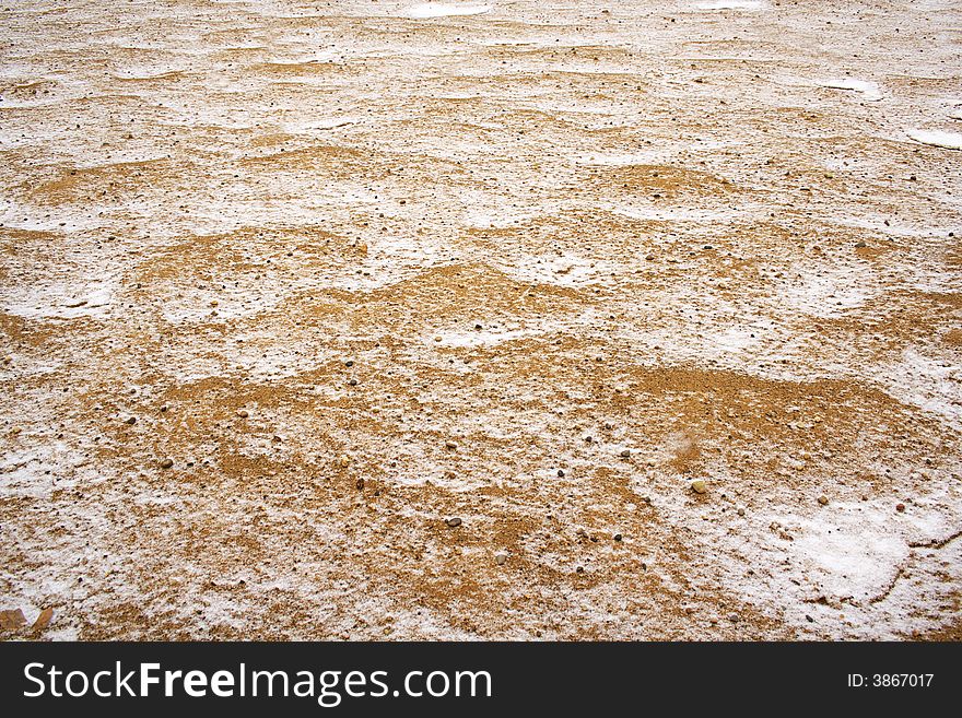 Sand covered with thin snow background in horizontal.