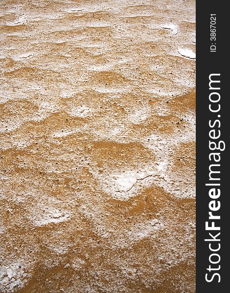 Sand covered by thin snow background in vertical