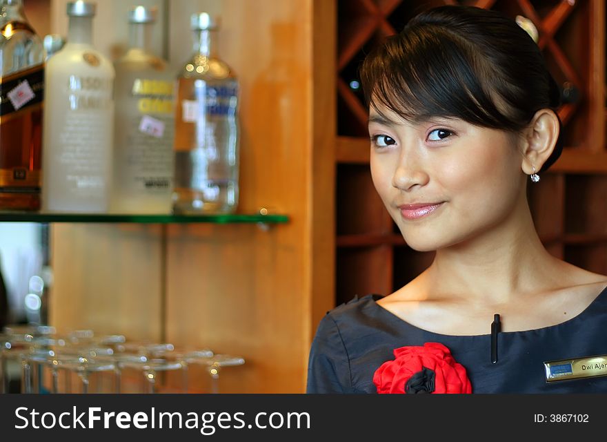 Beautiful asian bartender smiling at work