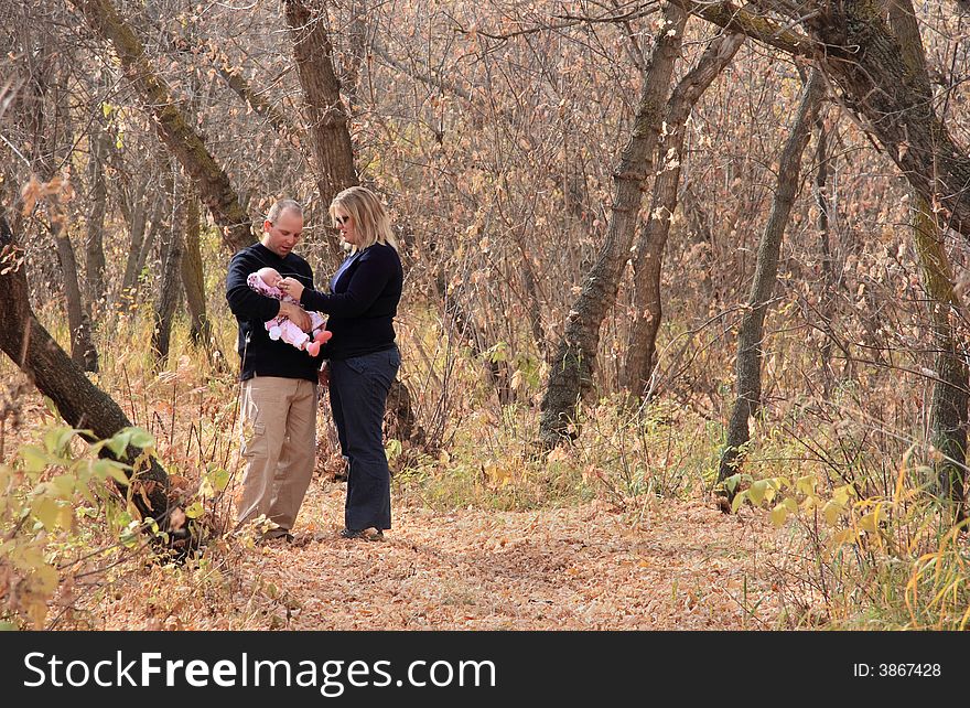 A young family enjoying a quiet moment while walking in the Autumn woods. A young family enjoying a quiet moment while walking in the Autumn woods.