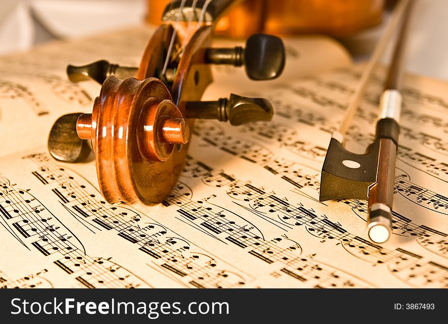 A violin and bow resting on a piece of aged classical music.