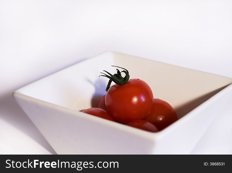 White bowl of tomatoes on white background. White bowl of tomatoes on white background