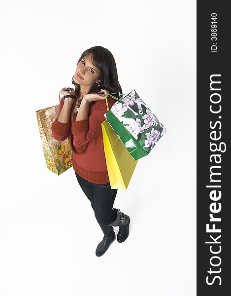 Pretty young woman with green, yellow and beige shopping bags. Pretty young woman with green, yellow and beige shopping bags