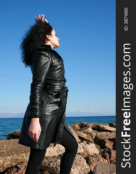 A young woman in leather jacket under the blue sky