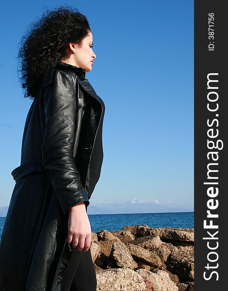 A young woman in leather jacket under the blue sky