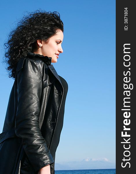 A young woman in leather jacket under the blue sky