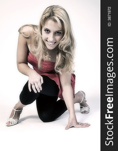 Studio portrait of a long blond girl on one knee