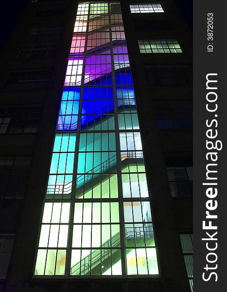 Modern multicolour building at night, each floor has been lit with a different colour bulbs. Modern multicolour building at night, each floor has been lit with a different colour bulbs