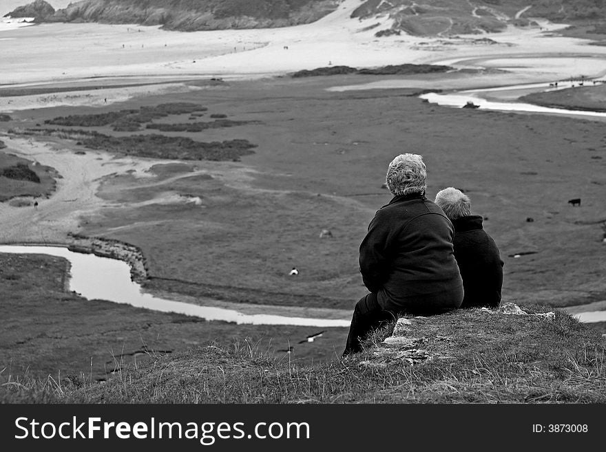 Senior couple taking in the view of Pennard valley in the gower peninsula. Senior couple taking in the view of Pennard valley in the gower peninsula