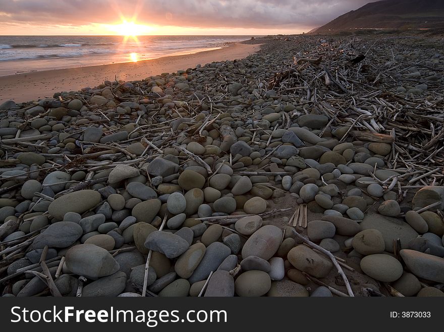 Driftwood and stones left on beach after a storm at sunset in Ventura, Ca. Driftwood and stones left on beach after a storm at sunset in Ventura, Ca.