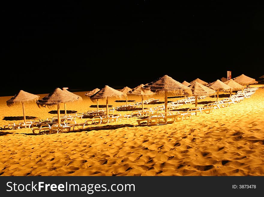 Group of sun shades on a beach at night. Group of sun shades on a beach at night