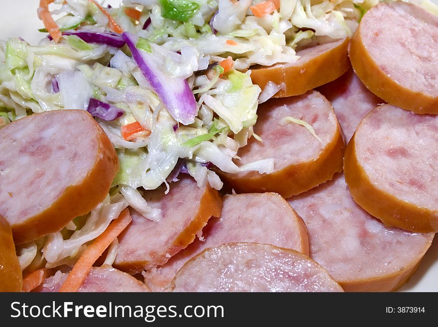 Sausage sliced with coleslaw in dish. Sausage sliced with coleslaw in dish