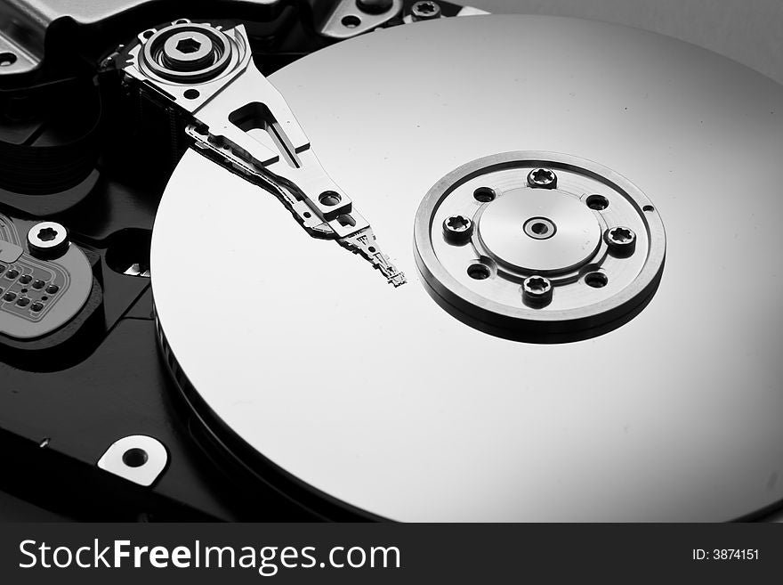 An exposed platter from a hard disk (disc) drive in black and white. An exposed platter from a hard disk (disc) drive in black and white.